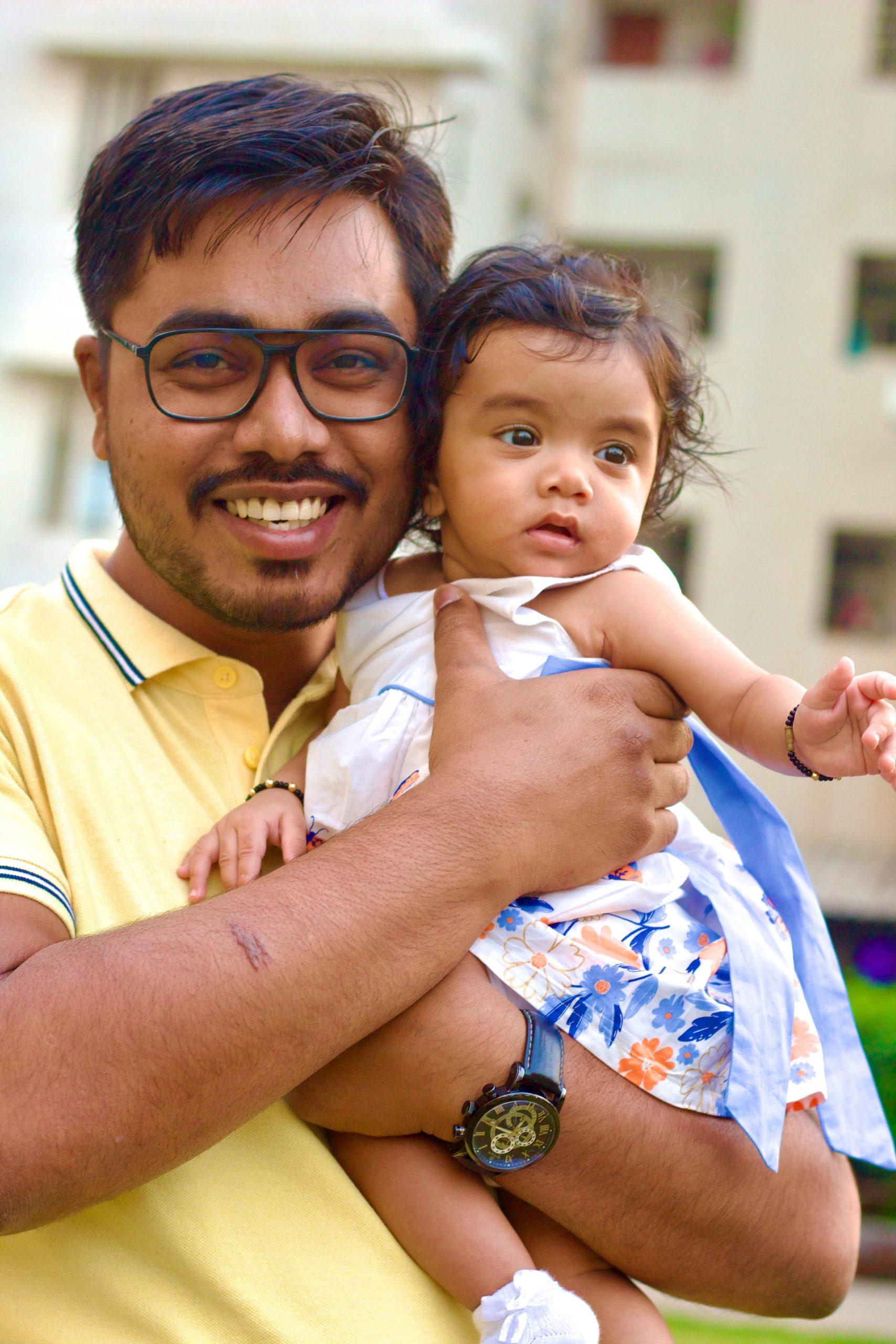 Joyful father holding his baby daughter in a happy moment outdoors.